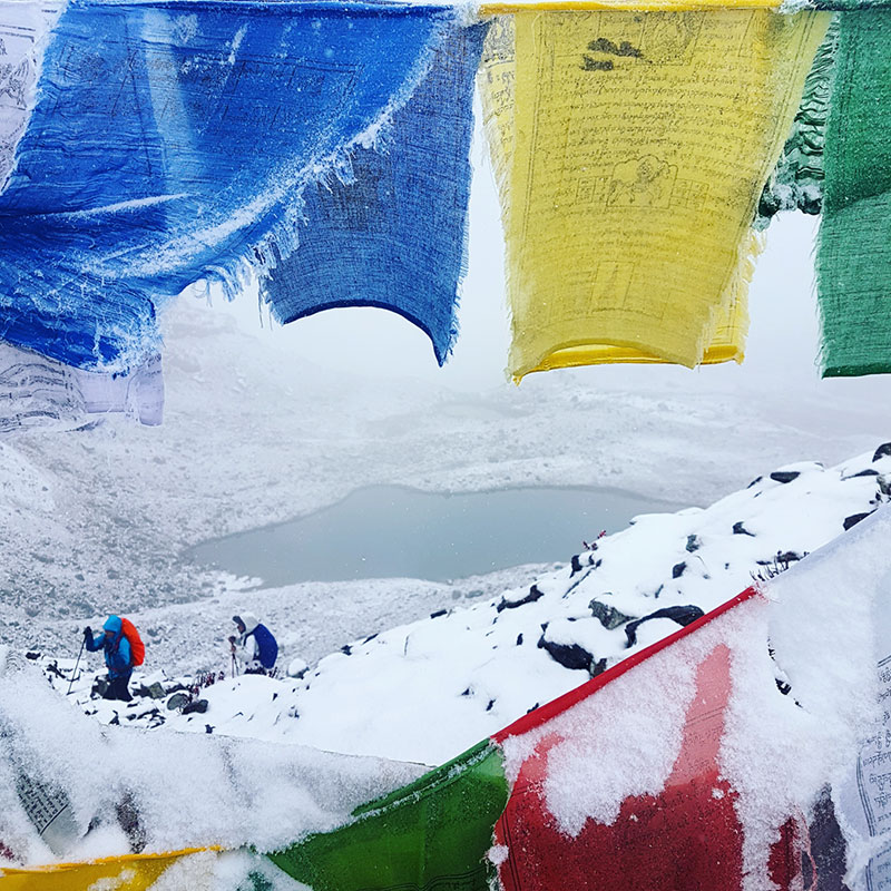 Trekkeurs et drapeaux de prières au col de Karakachu La, Bhoutan