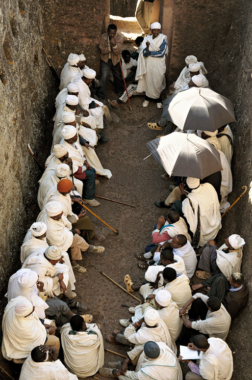 Groupe de prêtres assis dans une cavité à Lalibela, Ethiopie