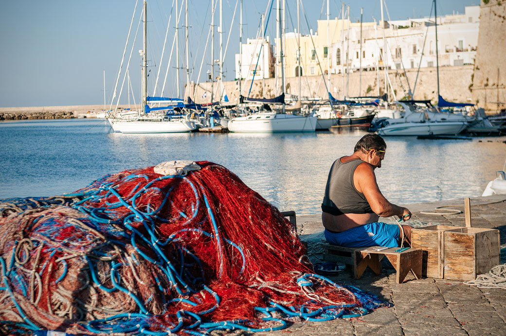 Pêcheur et filets sur un quai à Gallipoli, les Pouilles