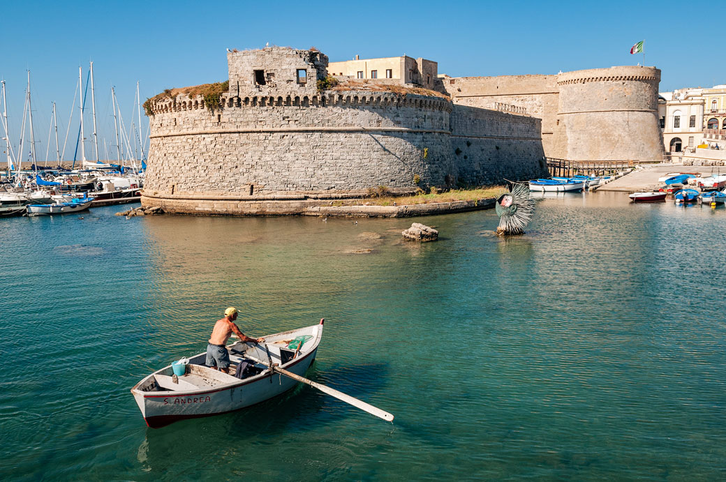 Homme dans une barque qui rame devant le château de Gallipoli